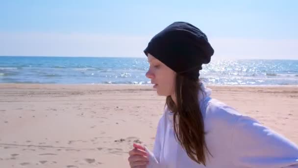 Молодая женщина бегает трусцой по морю песчаный пляж портрет бегун бег спортивный прикид на открытом воздухе — стоковое видео