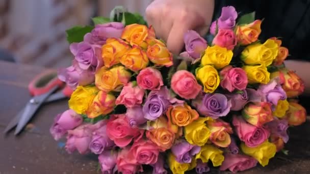 Bloemist vrouw werkt maakt boeket van kleurrijke rozen in winkel, close-up uitzicht. — Stockvideo