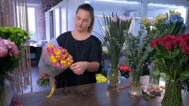 Kadın çiçekçi çiçekçi beyaz kağıt gül ambalaj buket.