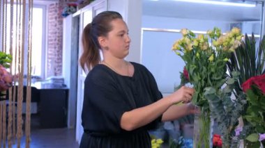 Çiçekçi kadın işleri çiçek dükkanında bej Eustoma buket yapar.