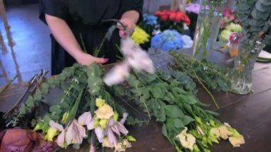 Çiçekçi Çiçek dükkanında okaliptüs, Eustoma, şakayık ve iris buket oluşturur.