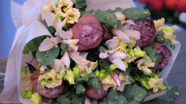 Великий милий ніжний букет евкаліпта, еустоми, півонії та ірису в квітковому магазині . — стокове відео