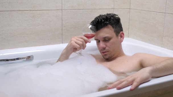 Ubriaco uomo si sta addormentando con bicchiere di vino in bagno . — Video Stock