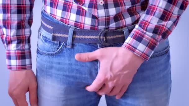 男は手でタイトなジーンズで彼のディックを修正します. — ストック動画