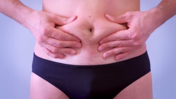 Man in onderbroek schudt zijn slappe vet naakte maag, close-up uitzicht. — Stockvideo