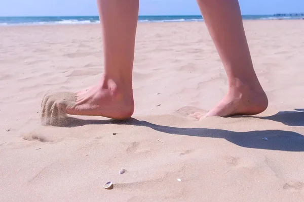女性は休暇中に休む海のビーチで砂の上に裸足で歩く, 砂の足. — ストック写真