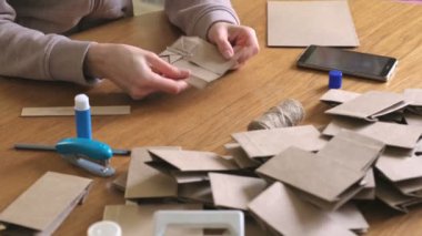 Kadın gelişi takvim için kraft kağıt tan bir kağıt torba yapar. Eller yakın çekim.