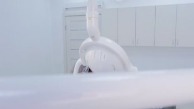 Diş hekimi stomatoloji kliniğinde genç kadının dişlerini tedavi ediyor, tedavi prosedürü.