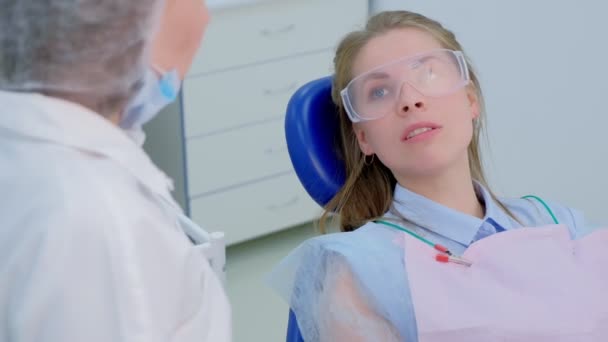 Mulher paciente falando sobre seus problemas de dentes ao dentista na clínica de estomatologia . — Vídeo de Stock