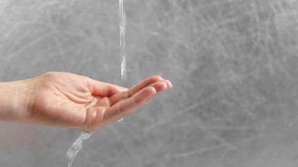 Water stroomt door de dames hand. Vrouw probeert te houden van water in Palm. Time concept. — Stockvideo