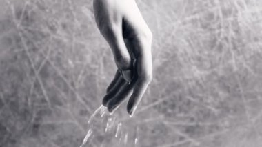 Su, kadının elinden akar. El yakın çekim.