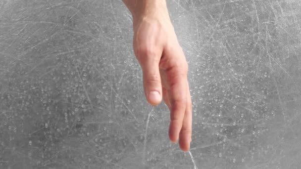 Water flows through the mans hand on grey background. Hand close-up. — Stock Video