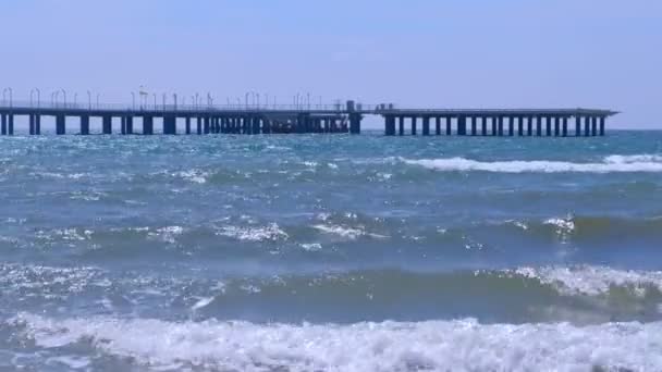 風の強い日に海と嵐の海の波でヘリコプタープラットフォームと大きな桟橋. — ストック動画