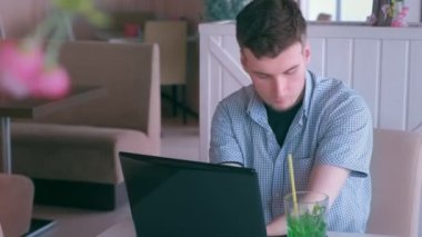 Güdük elleri ile engelli adam dizüstü bilgisayar ve görüşmeler cep telefonu kafede çalışıyor.