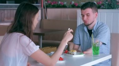 Kafede kadın ile tarihte iki amputated kütük elleri engelli adam rulo yiyor.