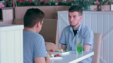 İki tane kütüğü olan engelli adam arkadaşıyla buluşup kafede konuşuyor.