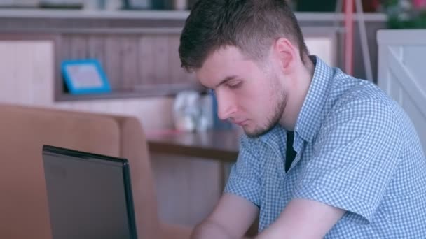 Jeune homme handicapé avec amputé deux mains souches dans les types de travaux de café sur ordinateur portable .