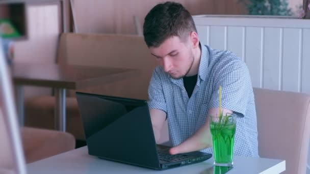 Handikappade mannen frilansare stubbe händer fungerar i Café på laptop och drinkar cocktail. — Stockvideo