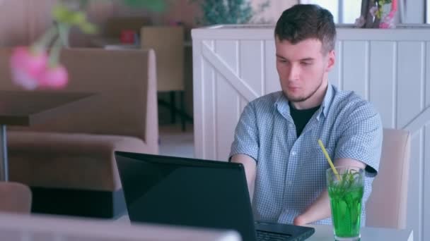 Disabled invalid man with stump hands works in cafe on laptop drinks cocktail. — Stock Video