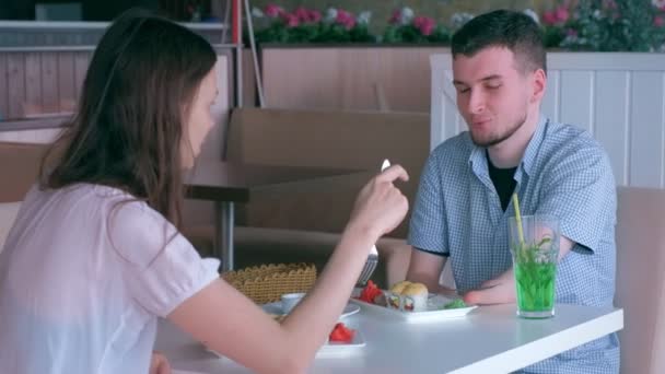 Gehandicapte man van twee geampuleerde stomp handen op datum met vrouw in Café eet broodjes. — Stockvideo