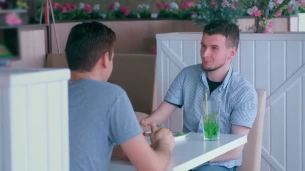 Handikappad man med två amputerade stubbe händer möter vän och pratar i Café. — Stockvideo