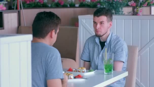 Un homme handicapé avec deux mains amputées rencontre un ami et parle dans un café . — Video