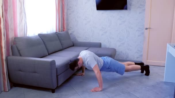 Funny nerd man is doing push-ups exercise and falling to the floor from  exhaustion at home. — Stock Video © familylifestyle #277723106
