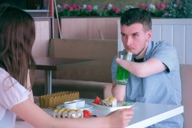 Kafede kadın ile tarihte iki amputated kütük elleri engelli adam rulo yiyor.