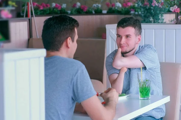 Инвалид с двумя ампутированными конечностями встречается с другом и разговаривает в кафе . — стоковое фото