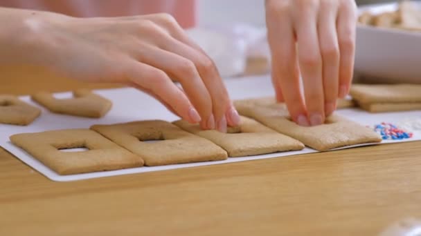 La mujer pone galletas dulces para las casas de jengibre en el tablero. Cocinar casa casera de jengibre . — Vídeos de Stock