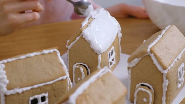 Жінки руки одягнули дах імбирного будинку з цукровою солодкою глазур'ю. Приготування домашнього імбирного будинку . — стокове відео