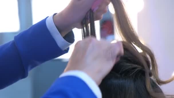 Cabelo estilista mãos trabalhando menina cabelo fazendo curles fixação pulverizador barbearia . — Vídeo de Stock