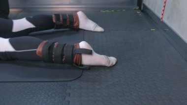 Eğitmen ipleri sabitleme sporcu bacaklar miyofascial germe için hazırlamak.