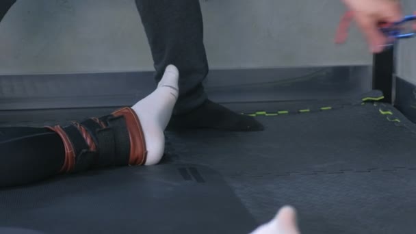 Entraîneur attacher fixateurs de cordes jambes sportif se préparer pour myofascial étirement . — Video