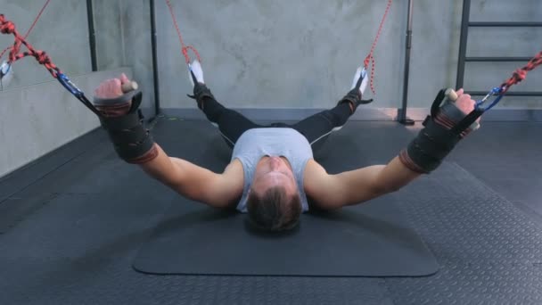 Ο αθλητής που κάνει ασκήσεις χρησιμοποιεί γυμναστή για τη γυμναστική που τεντώνει στον αέρα στο γυμναστήριο. — Αρχείο Βίντεο