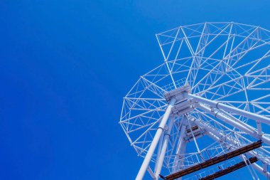 Güneşli bir günde mavi gökyüzü arka planda eğlence parkı dönme dolap kurmak.