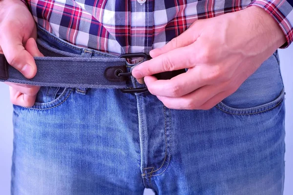 Erkek elleri mavi kot pantolon kemer ilerler.