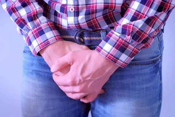 Homem quer fazer xixi, agarrando-se na virilha em jeans pelas mãos . — Fotografia de Stock