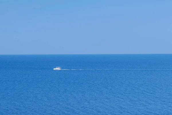 Λευκό μηχανοκίνητο σκάφος που πλέει στη θάλασσα την καλοκαιρινή ηλιόλουστη μέρα. — Φωτογραφία Αρχείου