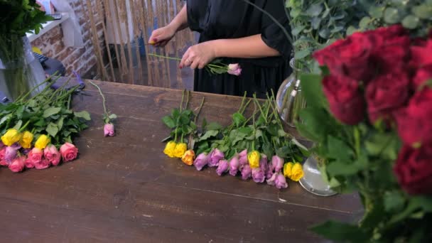 花屋の女性は、店でバラのとげを花束カットに花を準備し、クローズアップビュー. — ストック動画