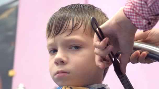 Peluquería corta pelos con un cortador en la cabeza de los chicos. Vista frontal, manos estilistas de cerca . — Vídeos de Stock