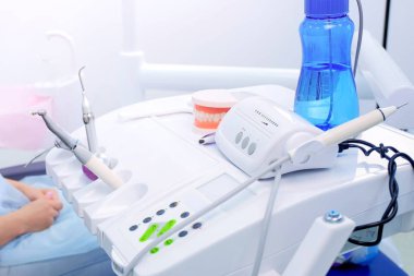 Kadın diş hekimi stomatoloji kliniğinde tedavi tıbbi ekipman kullanır, eller closeup.