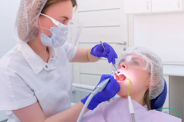 Zahnarzt putzt und poliert Frauenzähne mit Bohrmaschine in der Zahnmedizin. — Stockfoto