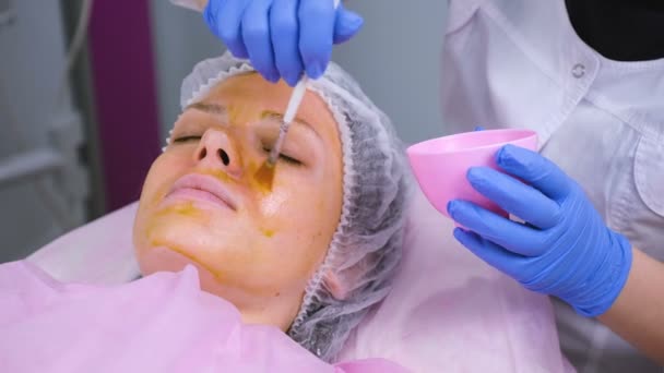 Beautician fırça ile kadın yüz kimyasal peeling koyar. Yüz derisinin temizlenmesi ve çillerin aydınlatılma. — Stok video