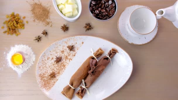 Verter el té en una taza de tetera. Panqueques rusos de chocolate, blini con relleno de cuajada en el plato . — Vídeo de stock