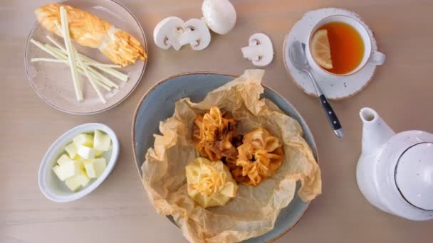 Julienne gebakken in deeg geserveerd op een plaat op baker papier met thee en boter. — Stockvideo