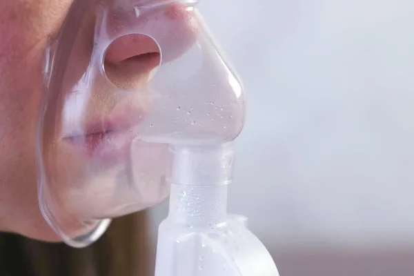 Nebulizatör ve astım tedavisi için kullanın. Genç kadın inhaler maskesi teneffüs edilmesi. Yakın çekim burun ve dudaklarını maskesindeki, yan görünüm. — Stok fotoğraf