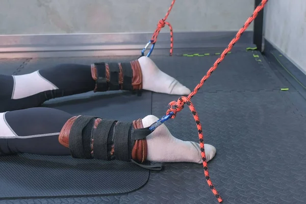 Entrenador sujetar cuerdas fijadores deportista piernas prepararse para el estiramiento miofascial . —  Fotos de Stock