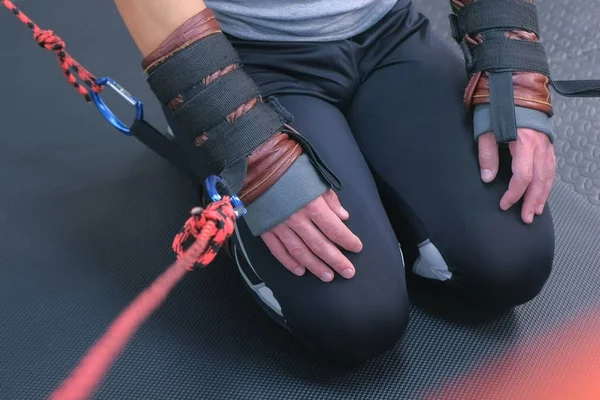 Tied hands and feet with ropes of sportsman preparing for myofascial stretching.