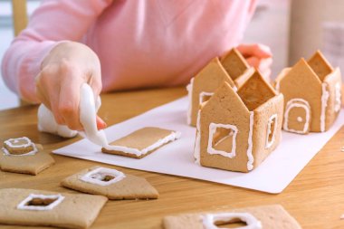 Womans eller zencefilli evler şeker tatlı krema ile ayrıntıları tutkallar olun. Pişirme ev yapımı zencefilli ev.